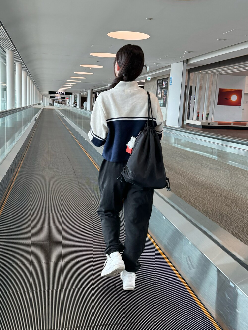 ホワイト系のスニーカー、ブラック系のスウェットパンツ、ブラック系のスウェットパンツを着用したレディースの秋コーディネートの4枚目の写真