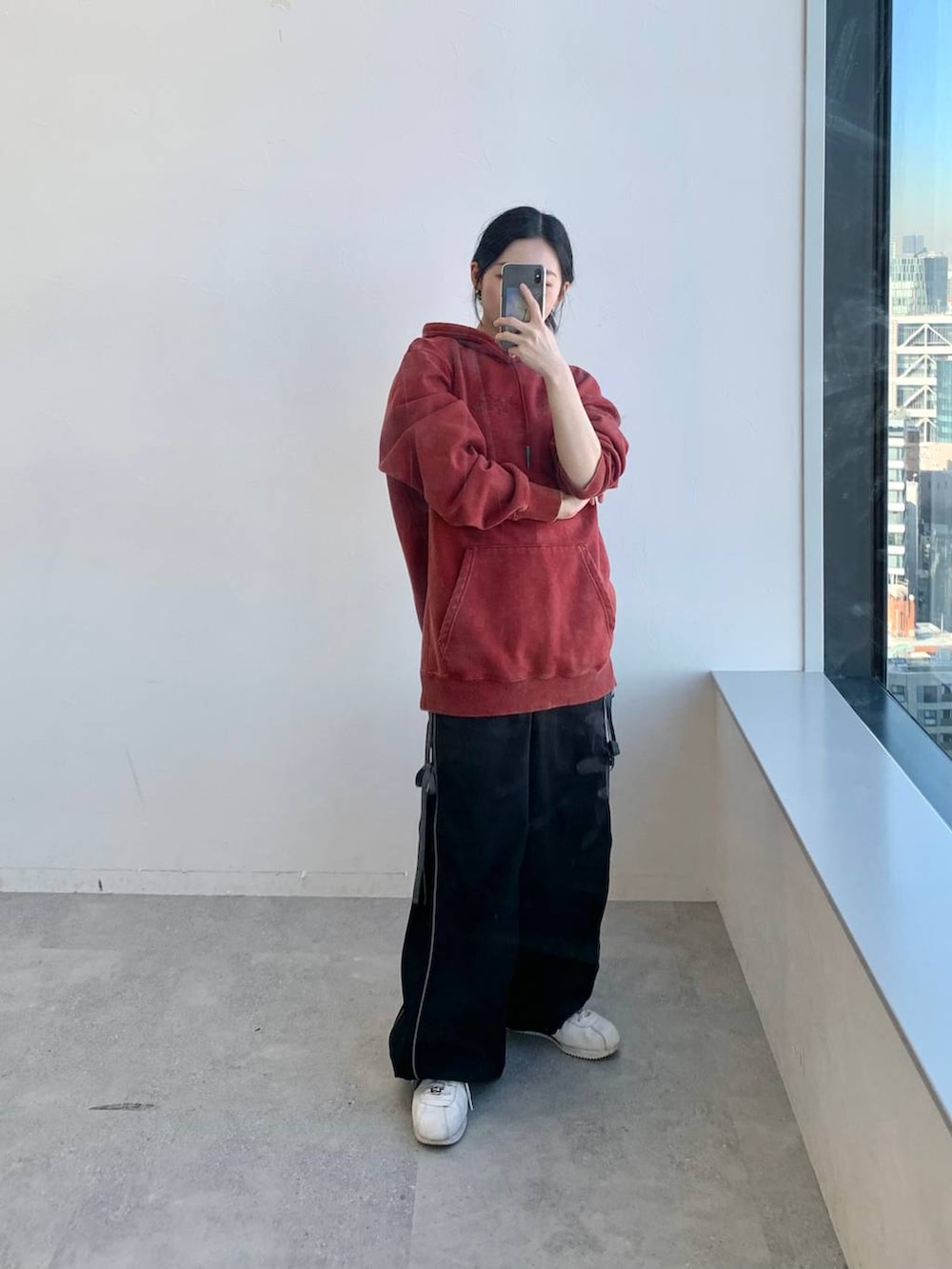 ブラック系のその他パンツ、レッド系のパーカーを着用したレディースの冬コーディネートの2枚目の写真