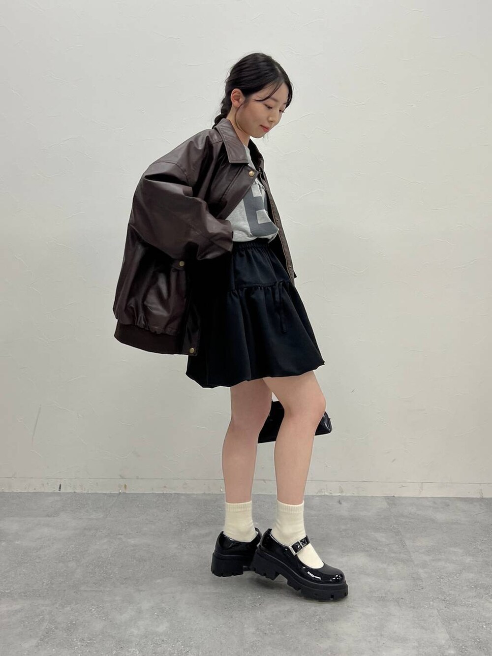 ブラウン系のブルゾン、グレー系のスウェット、ブラック系のハンドバッグを着用したレディースの冬コーディネートの4枚目の写真