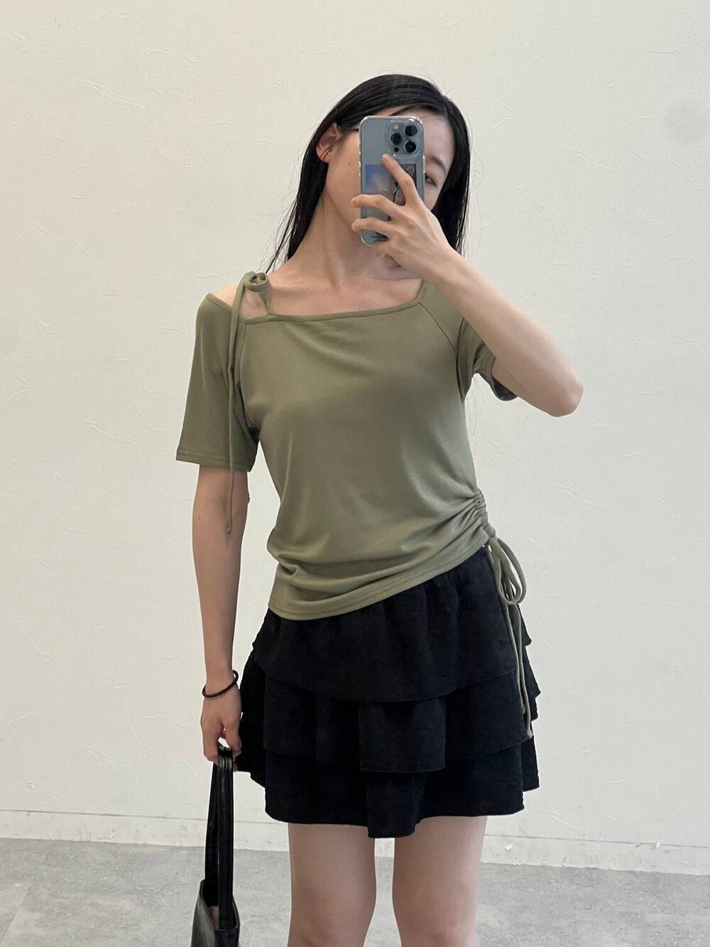 グリーン系のTシャツ/カットソー、ブラック系のハンドバッグ、ブラック系のスカートを着用したレディースの夏コーディネートの7枚目の写真