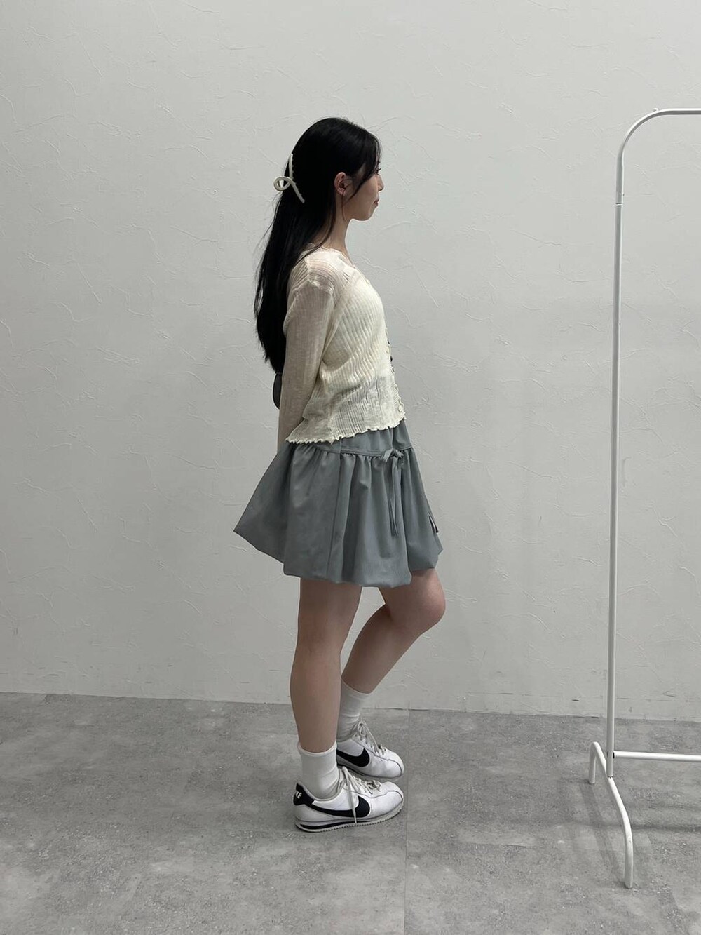 グレー系のスカート、ブラック系のトートバッグ、ベージュ系のカーディガン/ボレロを着用したレディースの夏コーディネートの5枚目の写真