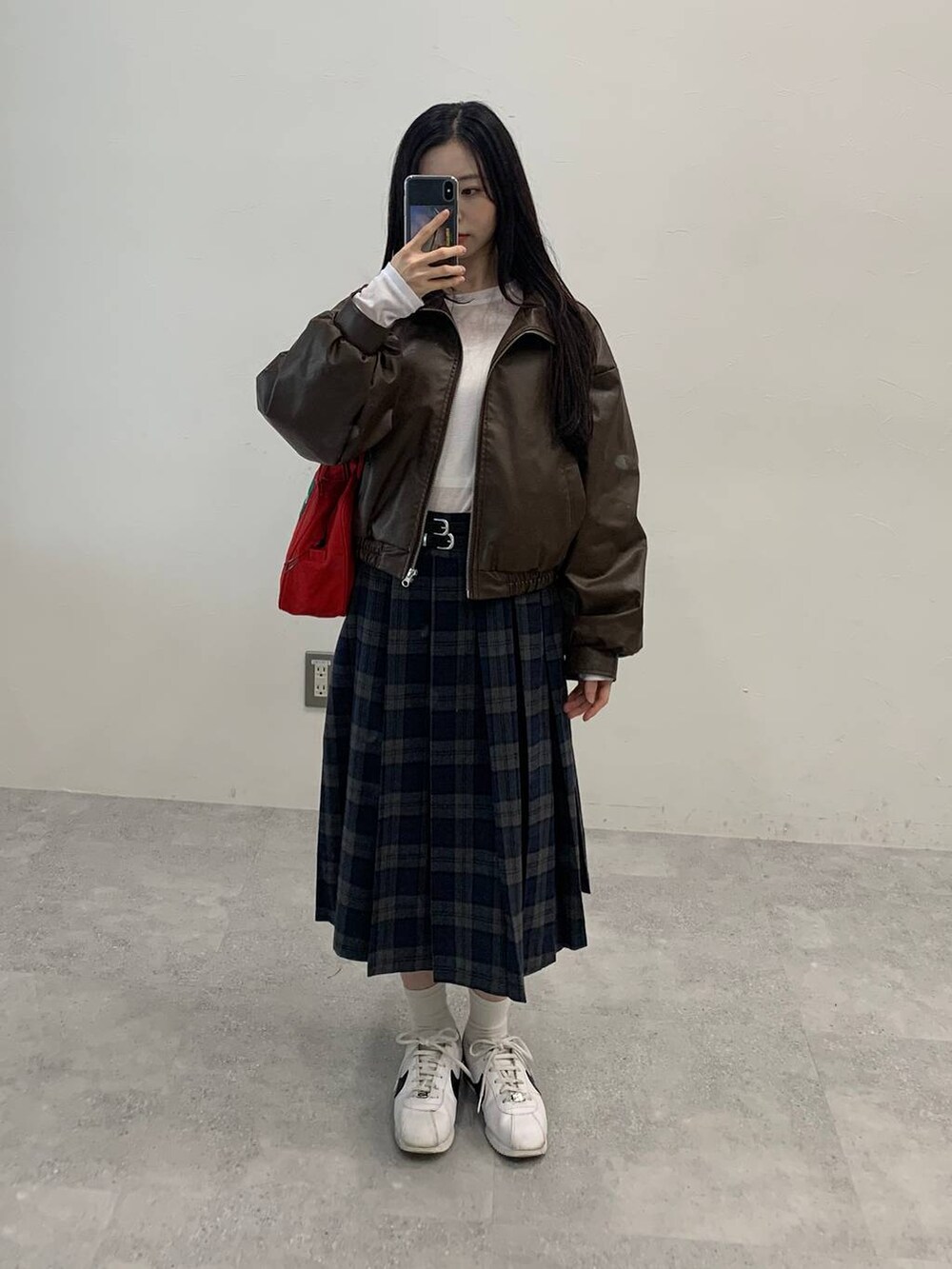 ブラック系のショルダーバッグ、ブラウン系のブルゾン、グレー系のスカートを着用したレディースの秋コーディネートの7枚目の写真