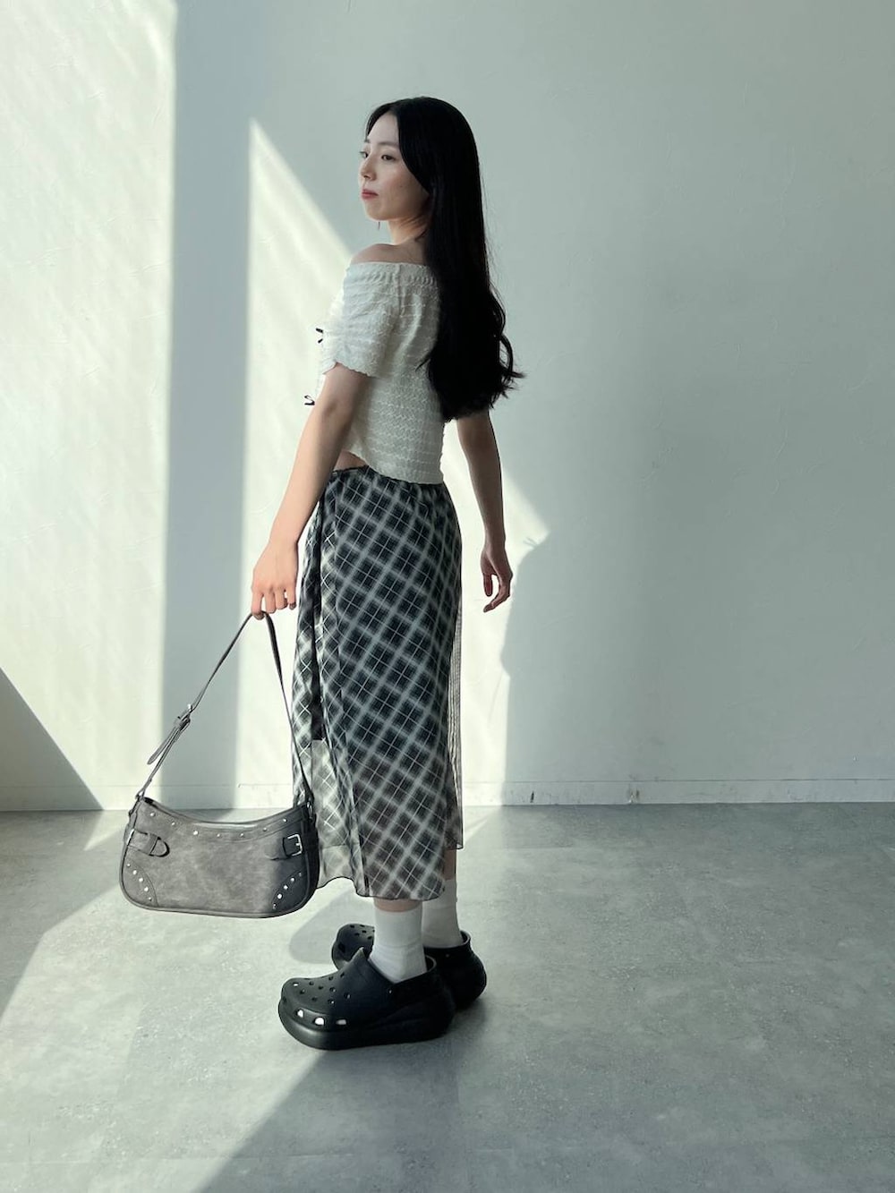 ホワイト系のTシャツ/カットソー、グレー系のスカート、ブラック系のトートバッグを着用したレディースの夏コーディネートの3枚目の写真