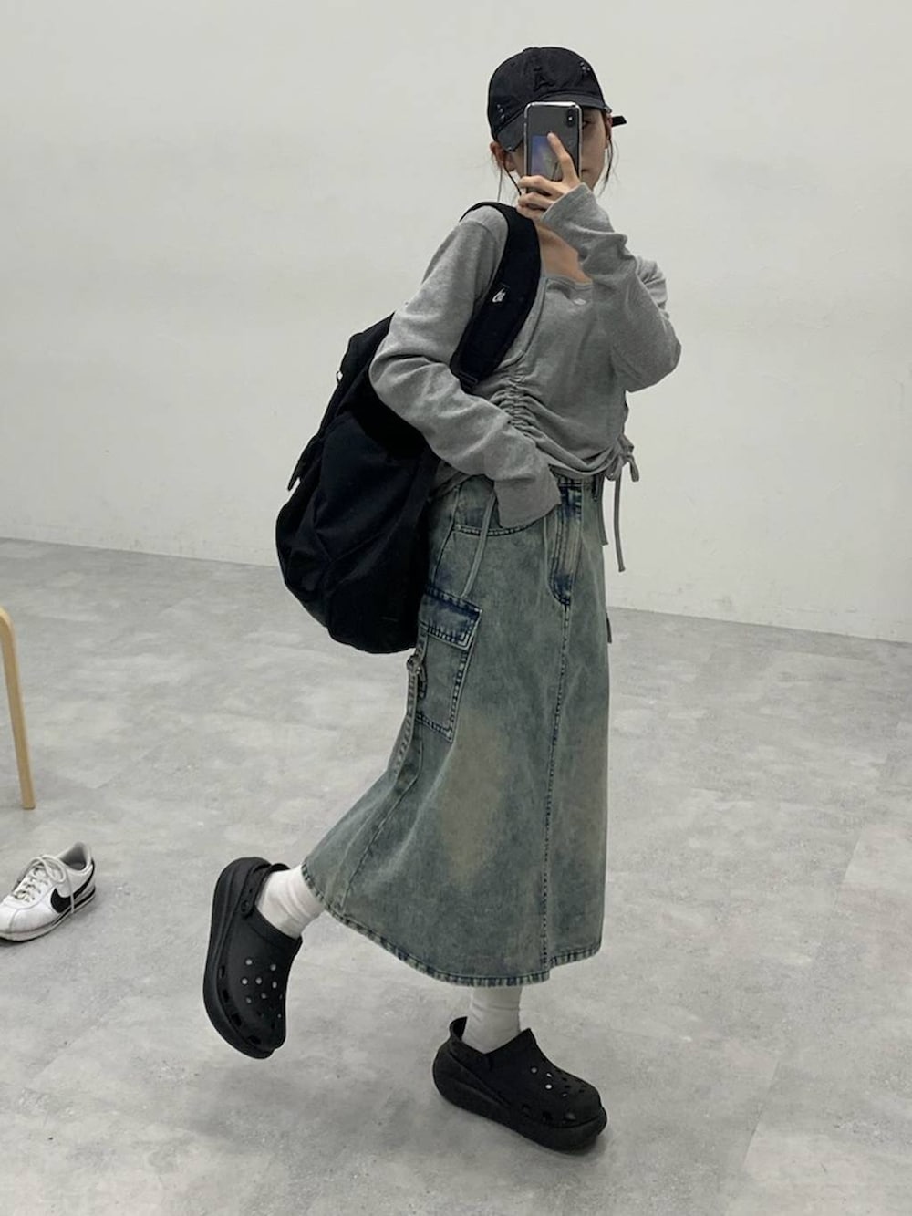 ブラック系のサンダル、ブルー系のデニムスカート、グレー系のTシャツ/カットソーを着用したレディースの秋コーディネートの6枚目の写真