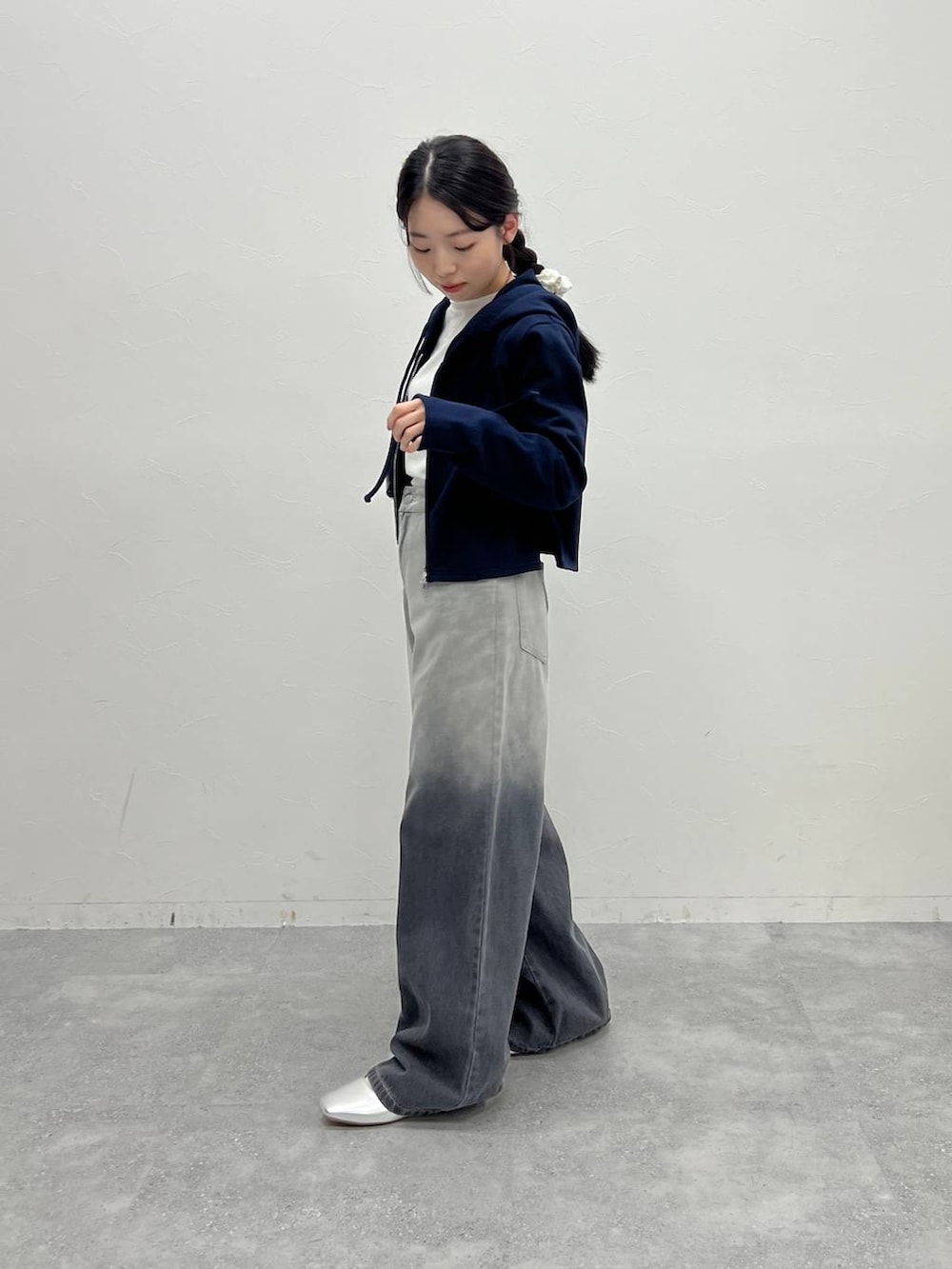 ブルー系のスウェット、ブラック系のデニムパンツ、ブラック系のハンドバッグを着用したレディースの冬コーディネートの4枚目の写真