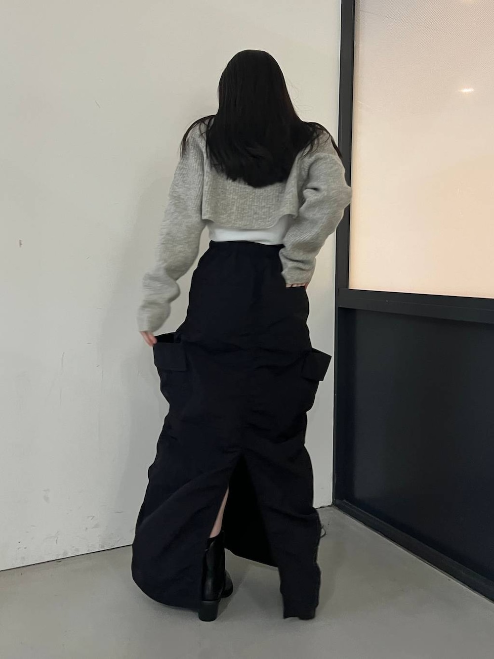 ブラック系のブーツ、ブラック系のスカート、グレー系のカーディガン/ボレロを着用したレディースの冬コーディネートの4枚目の写真
