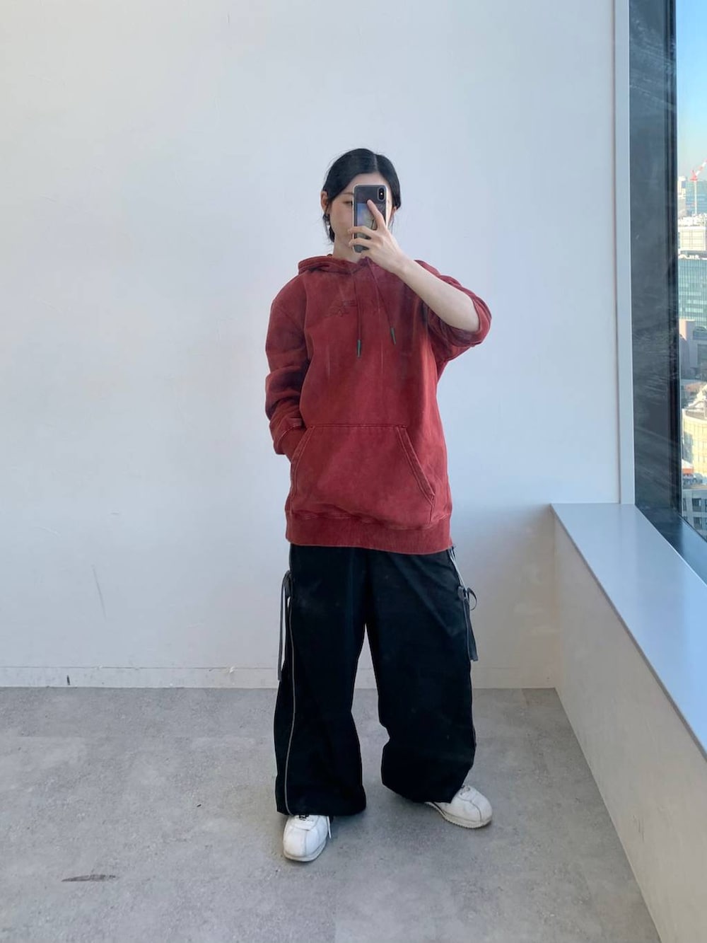 ブラック系のその他パンツ、レッド系のパーカーを着用したレディースの冬コーディネートの3枚目の写真