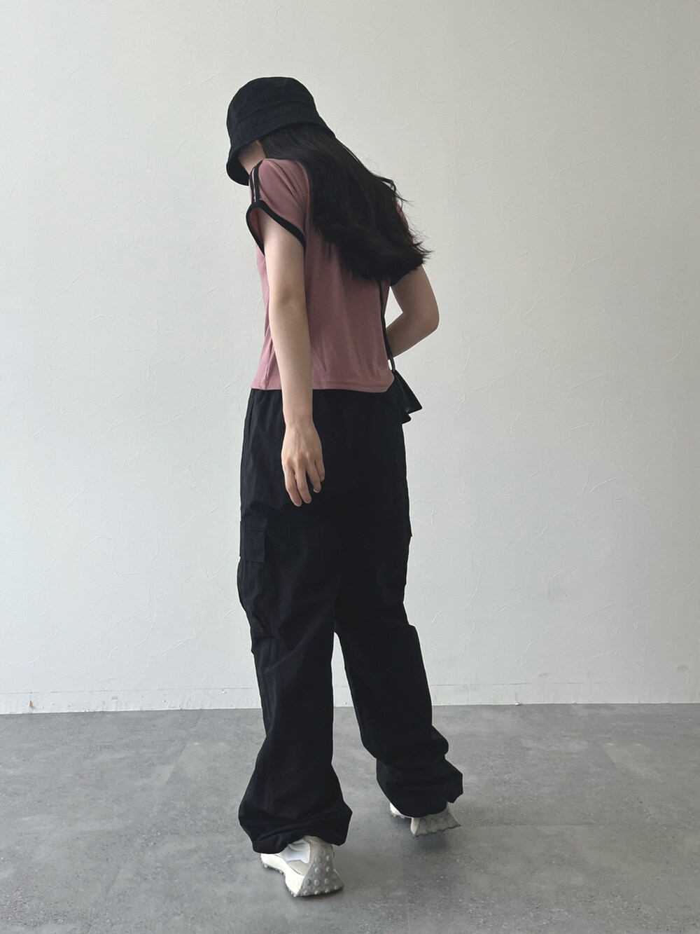 ピンク系のTシャツ/カットソー、ブラック系のショルダーバッグ、ブラック系のカーゴパンツを着用したレディースの夏コーディネートの3枚目の写真