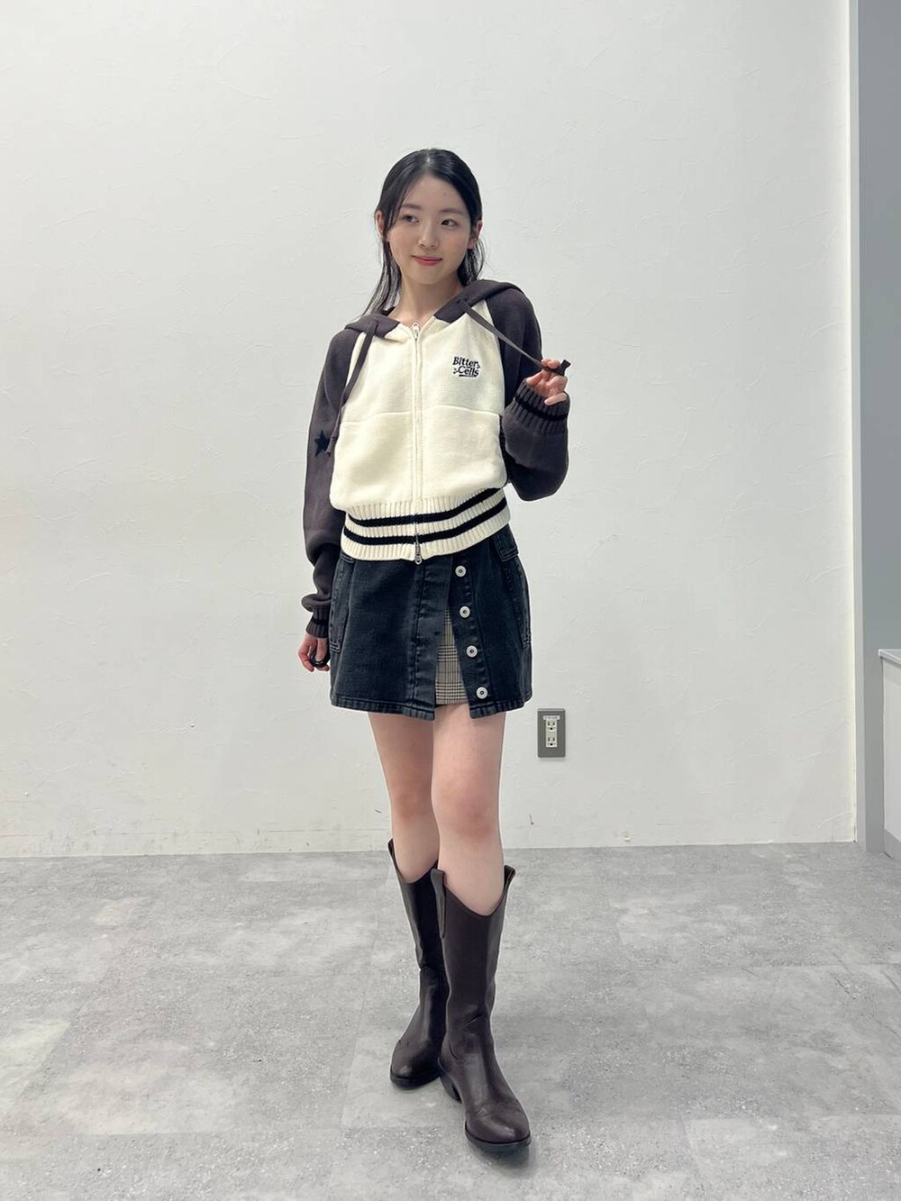 ブラウン系のスカート、ブラック系のデニムパンツを着用したレディースの春コーディネートの2枚目の写真