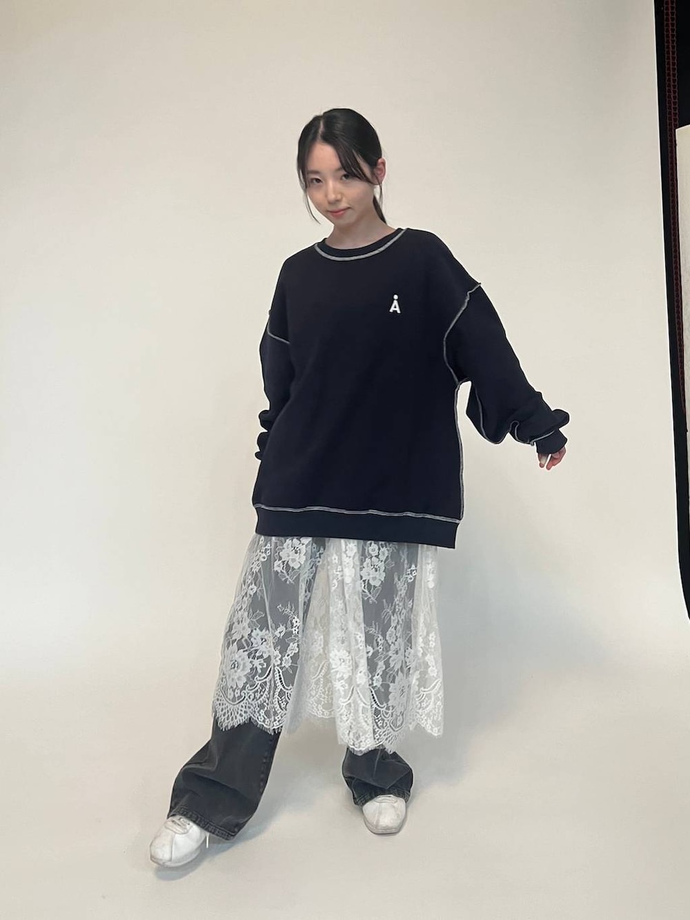 ブラック系のデニムパンツ、ブルー系のパーカー、ホワイト系のスニーカーを着用したレディースの冬コーディネートの2枚目の写真