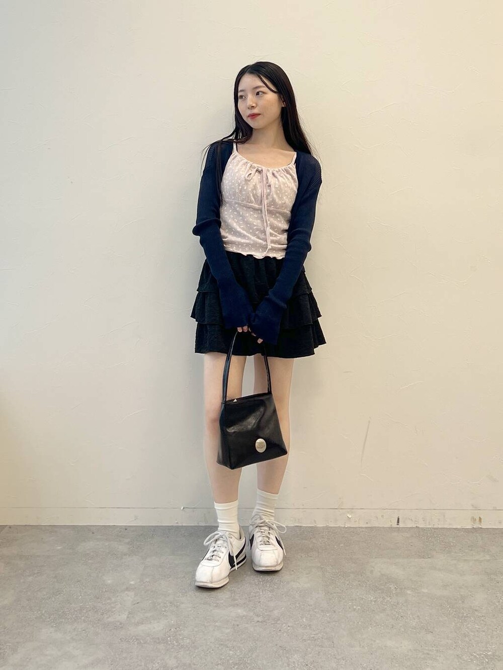 ピンク系のキャミソール、ブラック系のハンドバッグ、ブラック系のスカートを着用したレディースの夏コーディネートの2枚目の写真