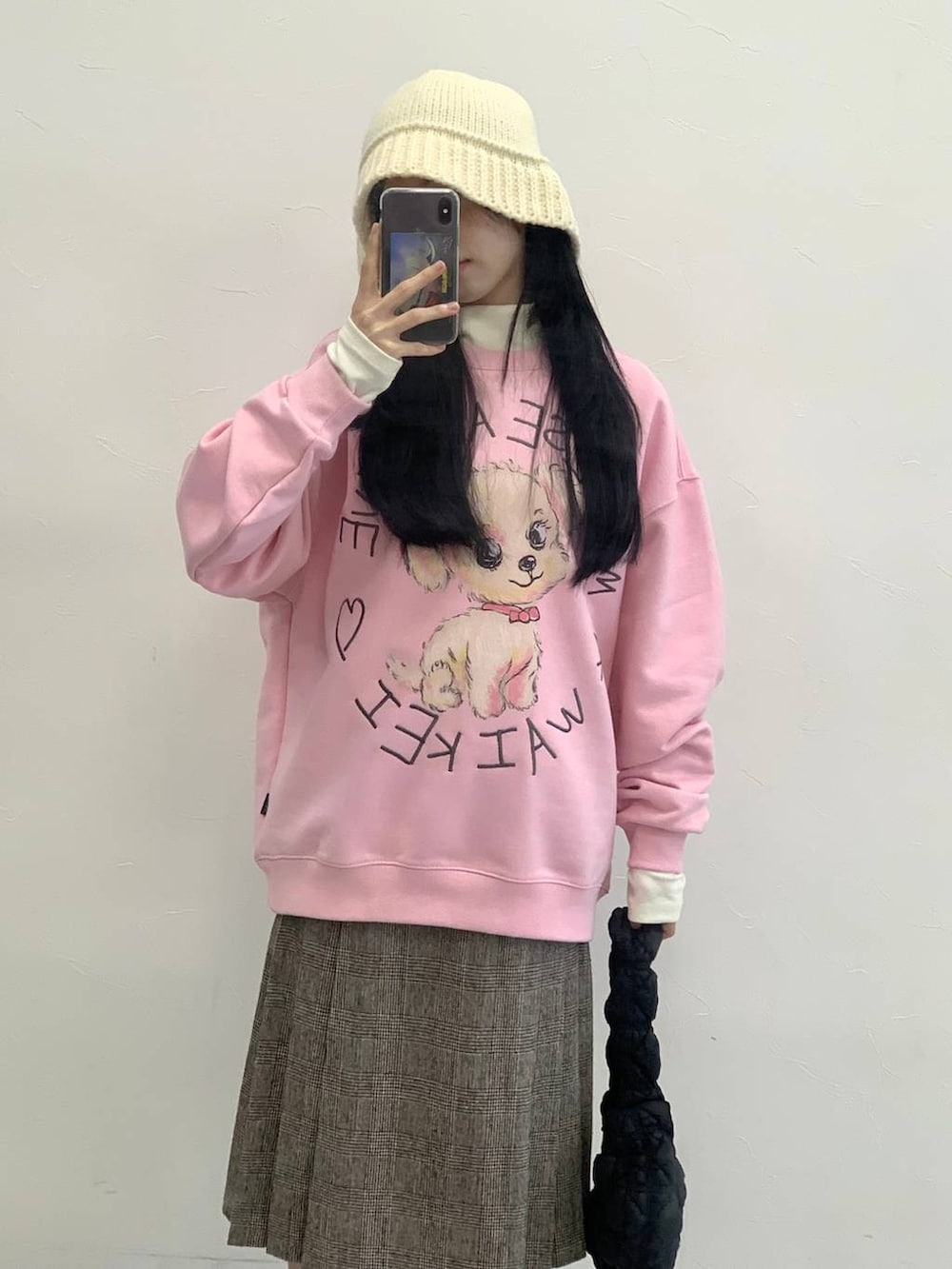 ブラック系のショルダーバッグ、ブラウン系のスカート、ピンク系のスウェットを着用したレディースの冬コーディネートの4枚目の写真