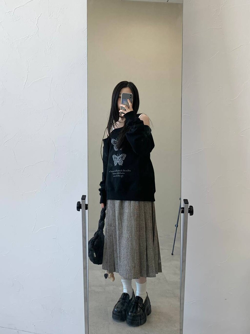 ブラック系のショルダーバッグ、ブラウン系のスカート、ブラック系のスウェットを着用したレディースの冬コーディネートの2枚目の写真