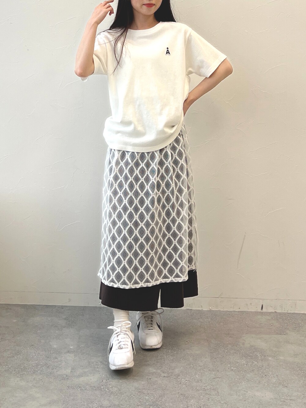 ホワイト系のTシャツ/カットソー、ベージュ系のスカートを着用したレディースの春コーディネートの2枚目の写真