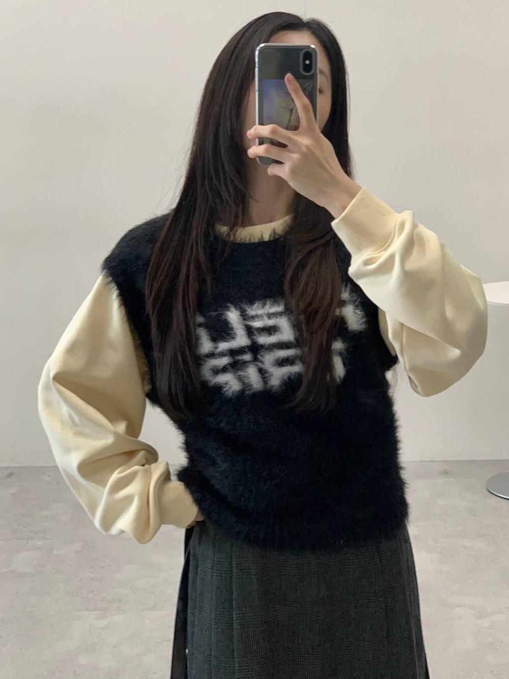 ベージュ系のスウェット、グレー系のスカート、ブラック系のハンドバッグを着用したレディースの冬コーディネートの5枚目の写真