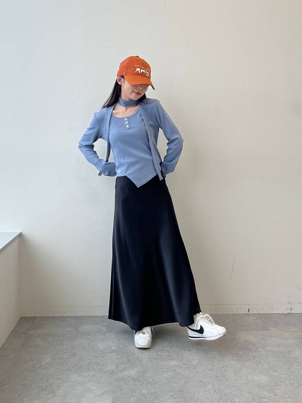 ブラック系のスカート、ブルー系のTシャツ/カットソー、ブラウン系のキャップを着用したレディースの春コーディネートの3枚目の写真