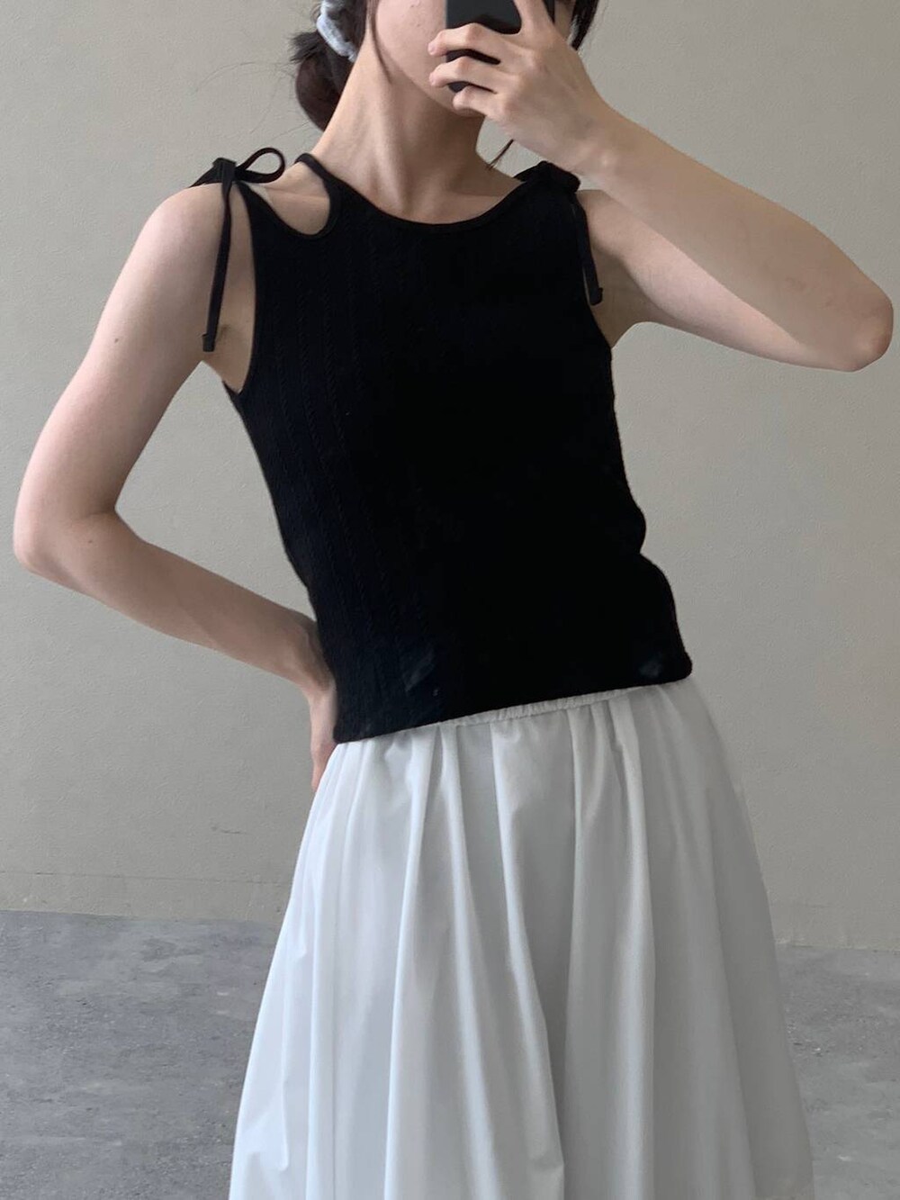 ホワイト系のスカート、ブラック系のキャミソールを着用したレディースの夏コーディネートの8枚目の写真