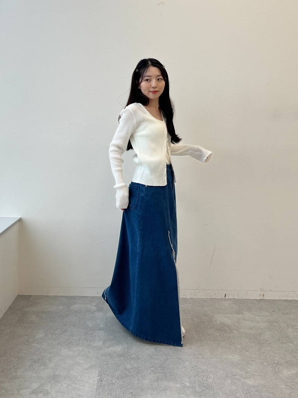 ブルー系のスカート、ベージュ系のカーディガン/ボレロを着用したレディースの春コーディネートの5枚目の写真