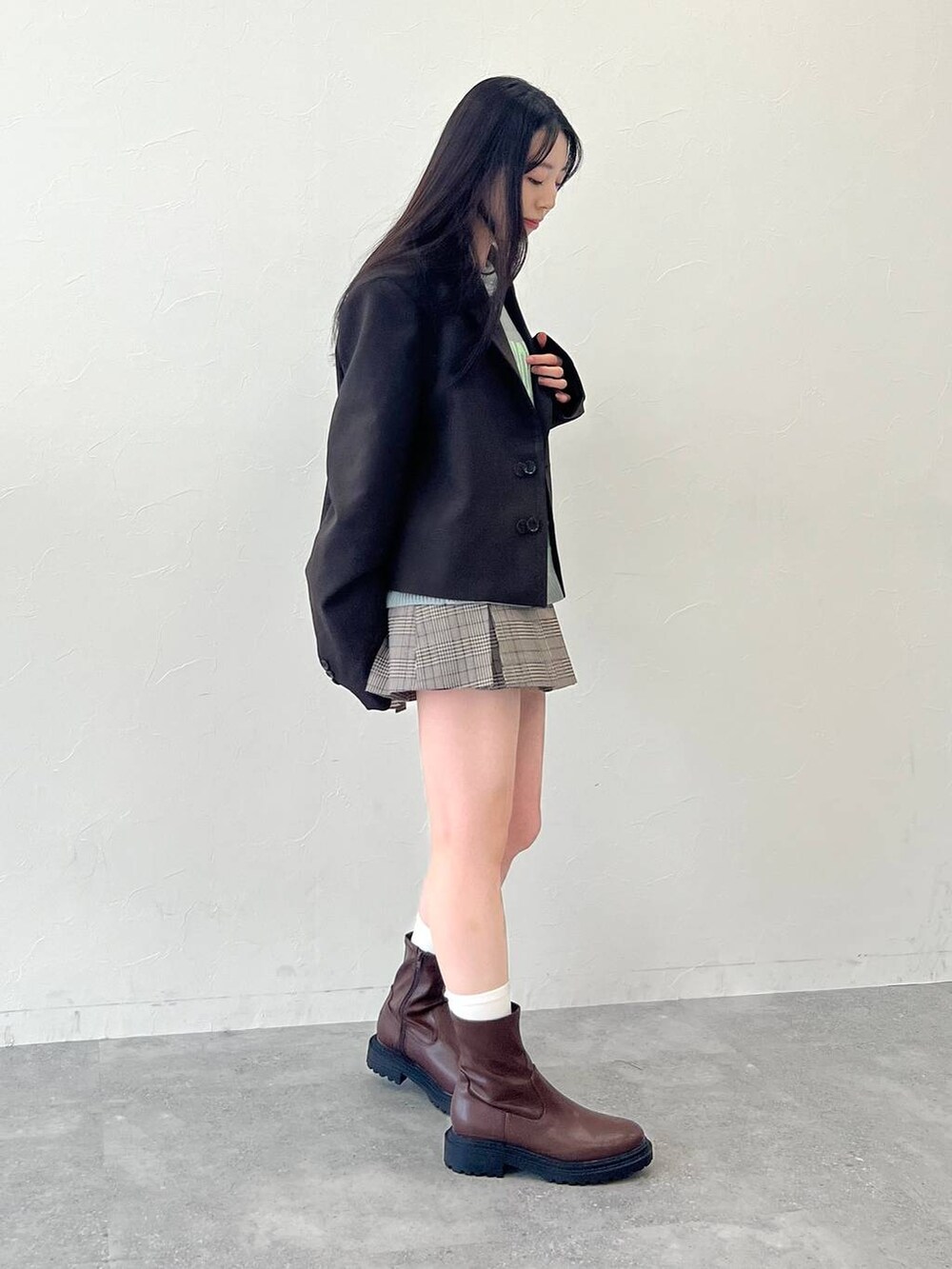 グレー系のニット/セーター、ブラウン系のスカート、ブラウン系のテーラードジャケットを着用したレディースの冬コーディネートの3枚目の写真