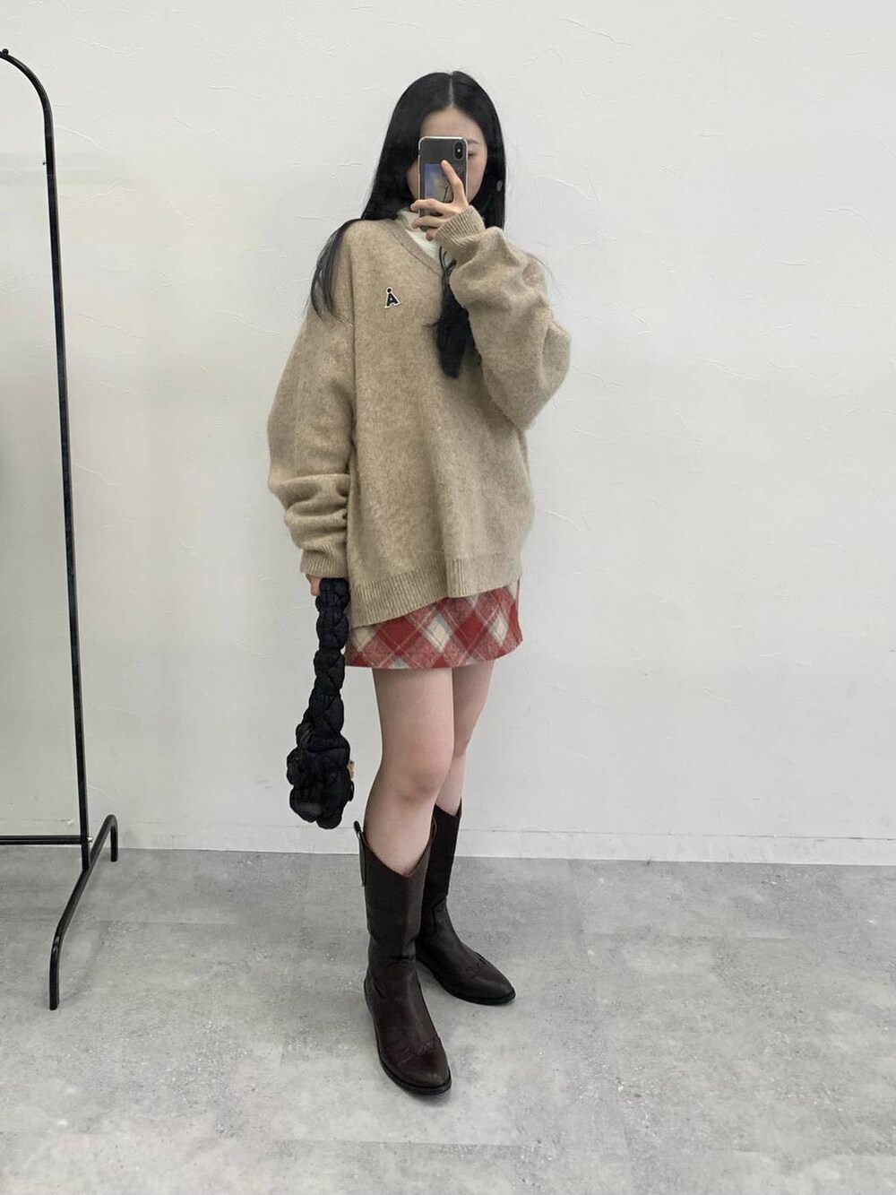 ブラック系のショルダーバッグ、レッド系のスカート、ベージュ系のTシャツ/カットソーを着用したレディースの冬コーディネートの3枚目の写真