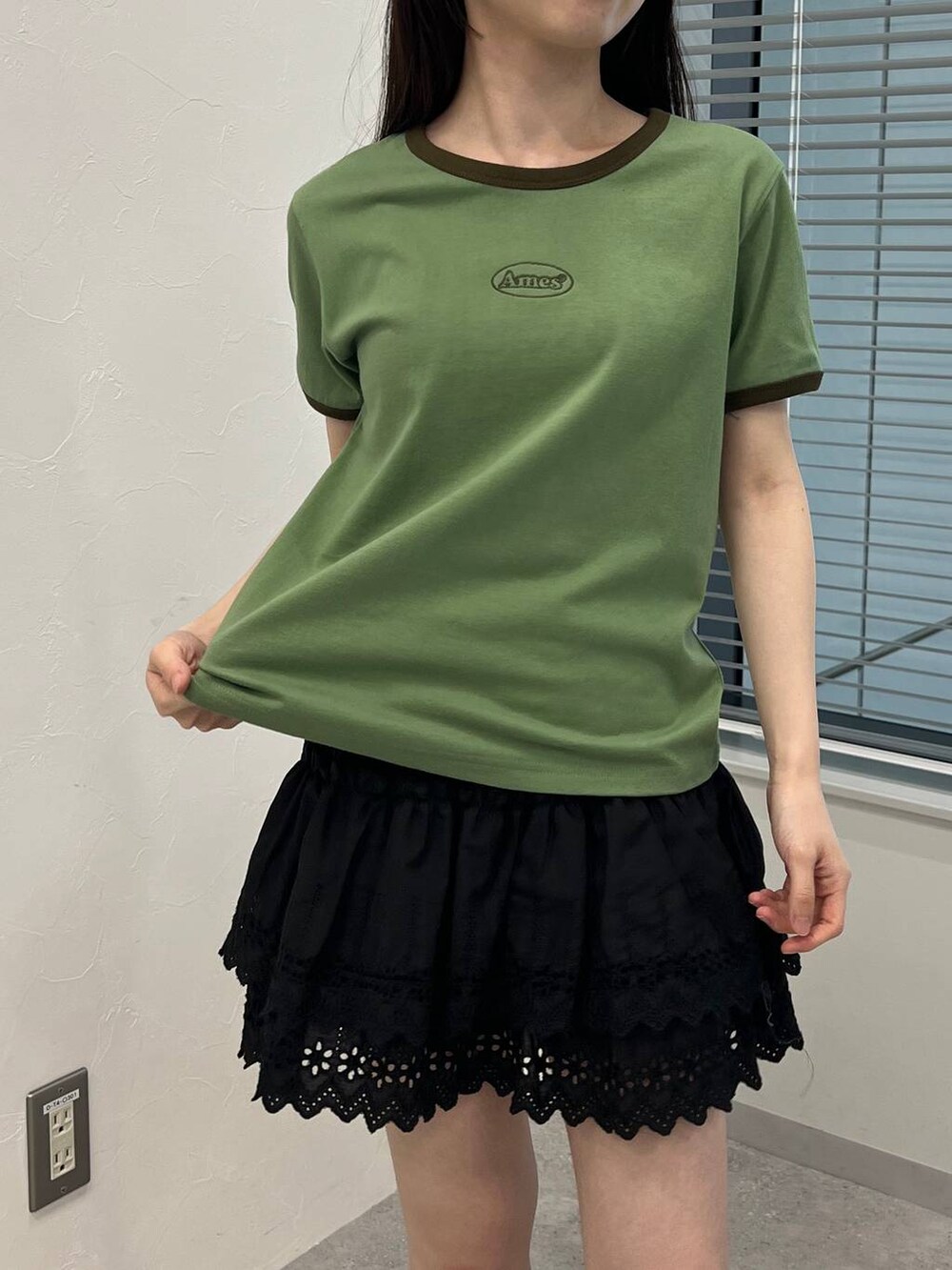 ブラック系のスカート、グリーン系のTシャツ/カットソーを着用したレディースの夏コーディネートの6枚目の写真