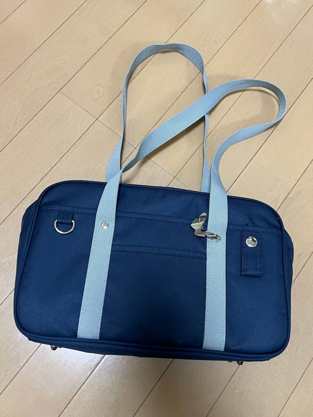 ブルー系のトートバッグ、ブラック系のジャケット/アウター、ホワイト系のTシャツ/カットソーを着用したレディースの冬コーディネートの6枚目の写真