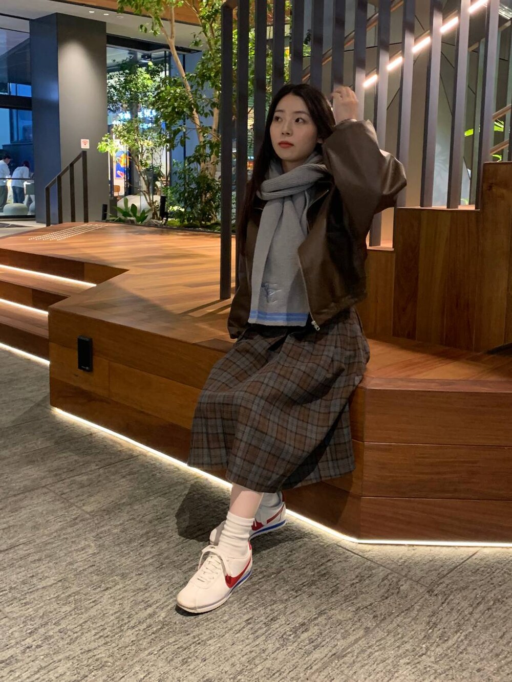 グレー系のカーディガン/ボレロ、ブラウン系のブルゾン、ブラウン系のスカートを着用したレディースの秋コーディネートの6枚目の写真