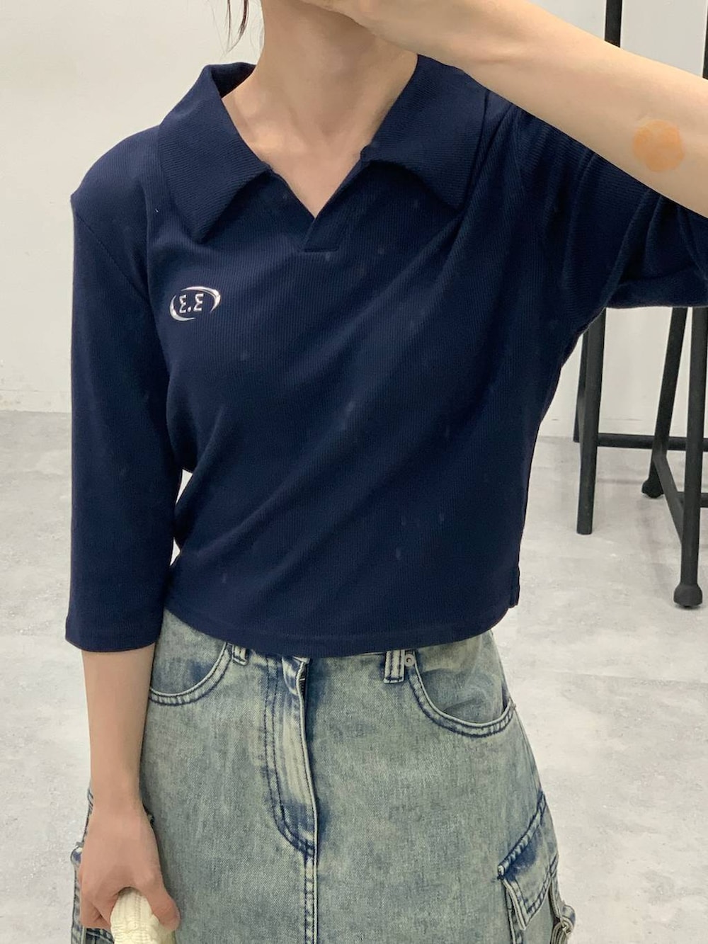 ブルー系のデニムスカート、ホワイト系のショルダーバッグ、ブルー系のTシャツ/カットソーを着用したレディースの秋コーディネートの6枚目の写真