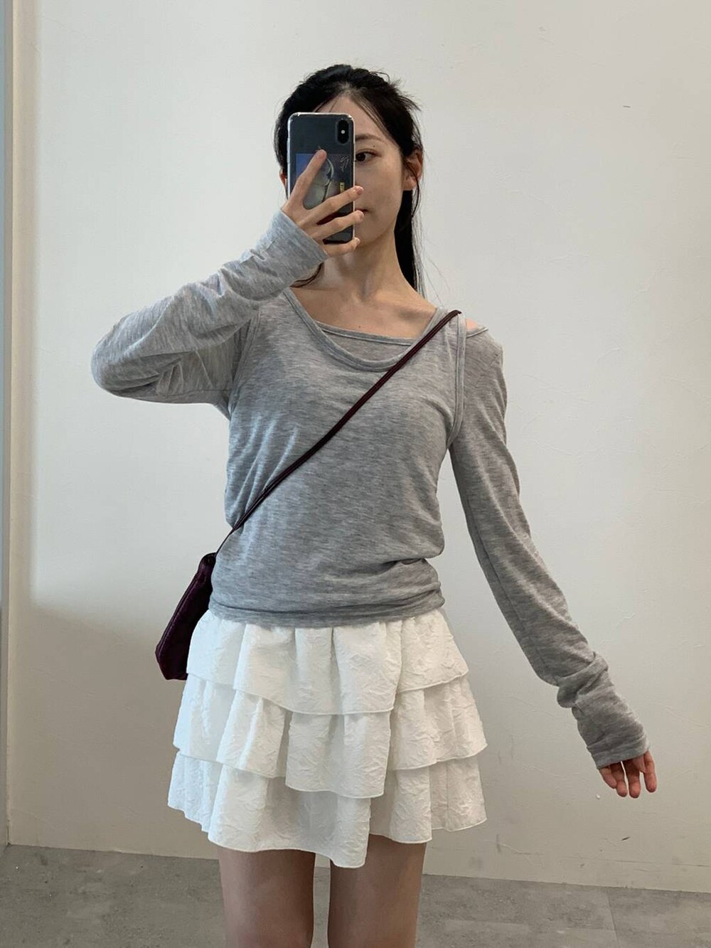 ホワイト系のスカート、グレー系のTシャツ/カットソーを着用したレディースの秋コーディネートの5枚目の写真