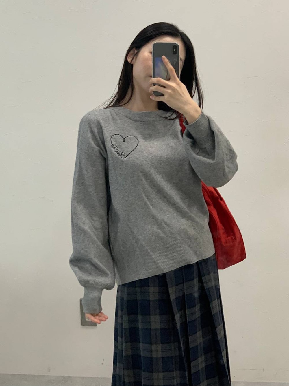 グレー系のニット/セーター、グレー系のスカートを着用したレディースの秋コーディネートの6枚目の写真