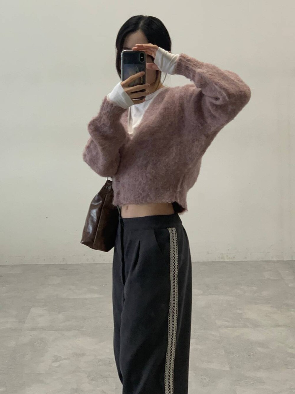 オレンジ系のカーディガン/ボレロ、グレー系のスラックス、ベージュ系のTシャツ/カットソーを着用したレディースの秋コーディネートの8枚目の写真