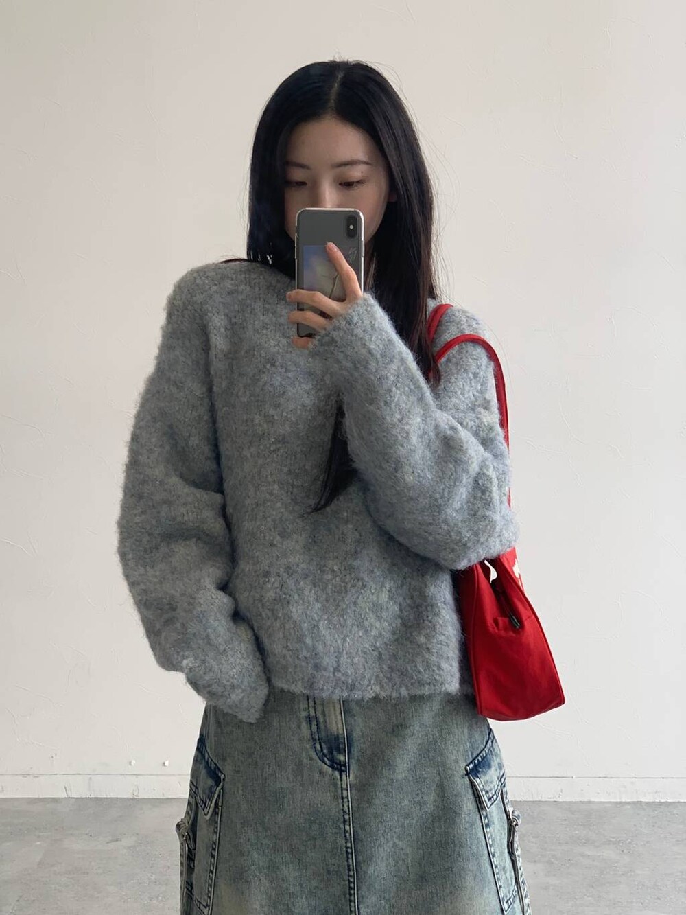 ブルー系のデニムスカート、グレー系のニット/セーターを着用したレディースの秋コーディネートの4枚目の写真