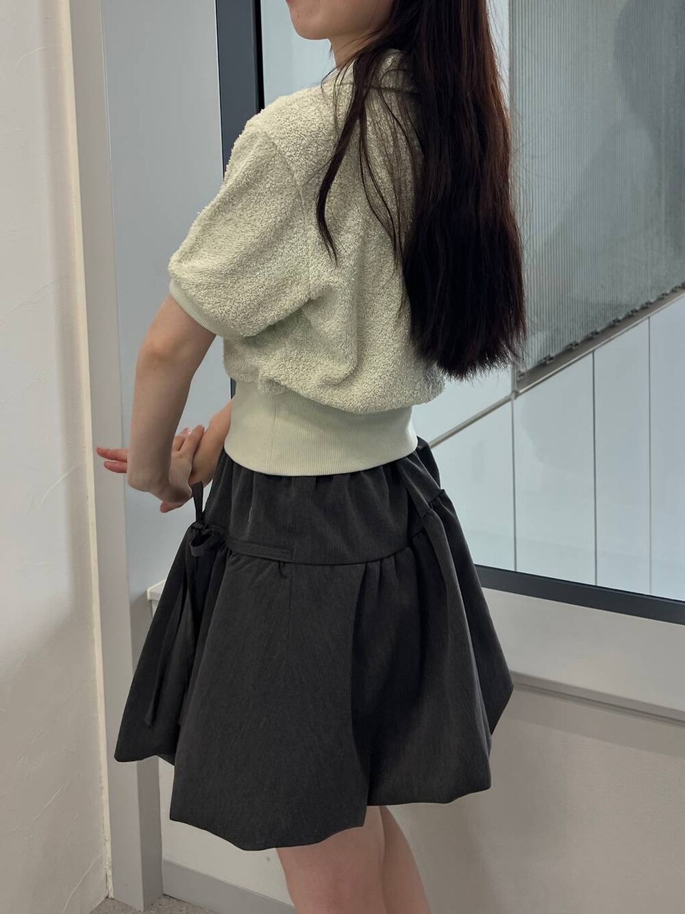 グレー系のスカート、グリーン系のTシャツ/カットソーを着用したレディースの夏コーディネートの5枚目の写真