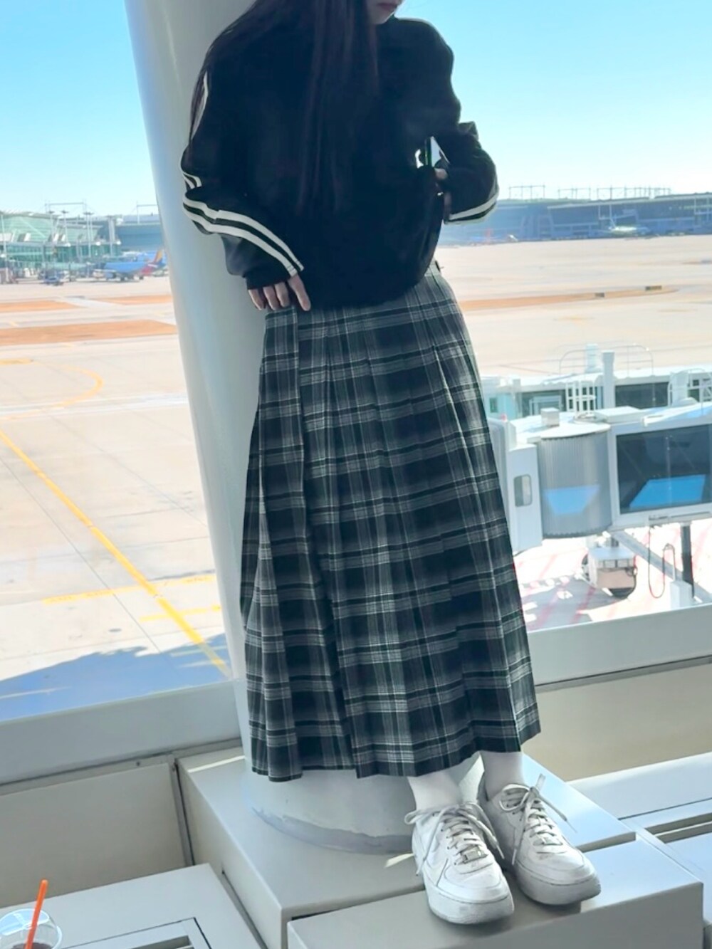 ホワイト系のスニーカー、グレー系のスカート、ブラック系のTシャツ/カットソーを着用したレディースの冬コーディネートの5枚目の写真