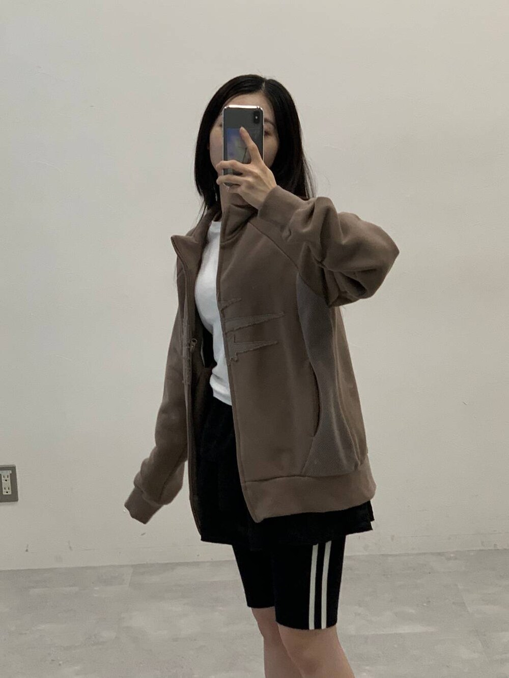 ブラック系のスカート、ベージュ系のパーカー、ブラック系のその他パンツを着用したレディースの秋コーディネートの6枚目の写真