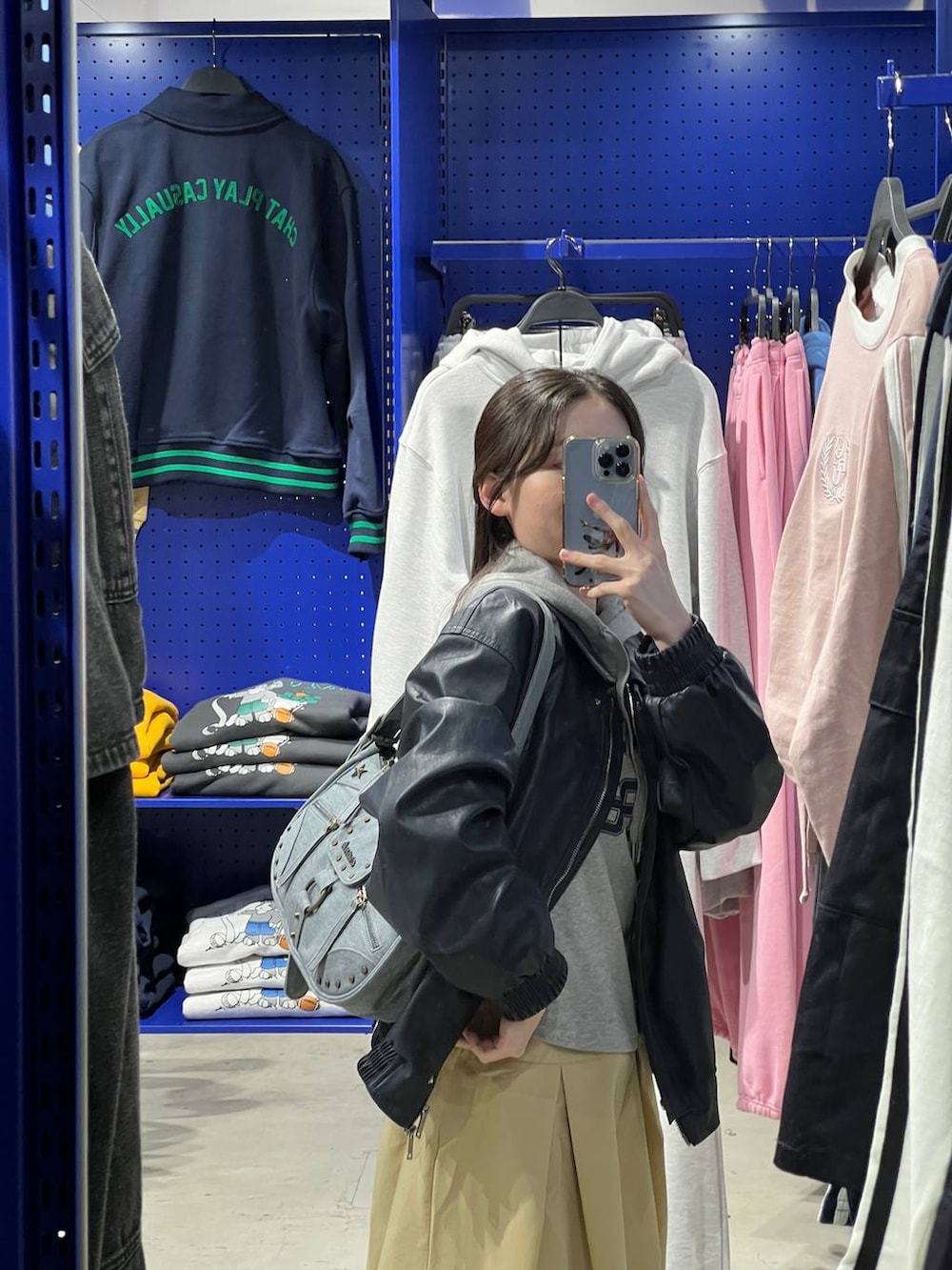 ベージュ系のスカート、ブルー系のブルゾン、グレー系のパーカーを着用したレディースの春コーディネートの5枚目の写真