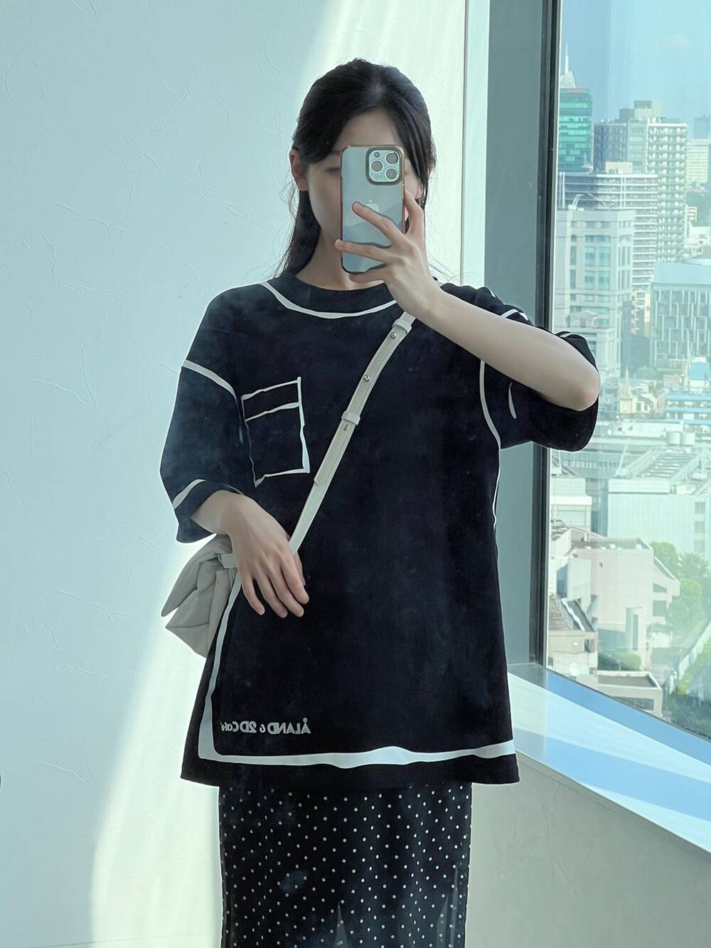 ホワイト系のハンドバッグ、ブラック系のスカートを着用したレディースの夏コーディネートの8枚目の写真