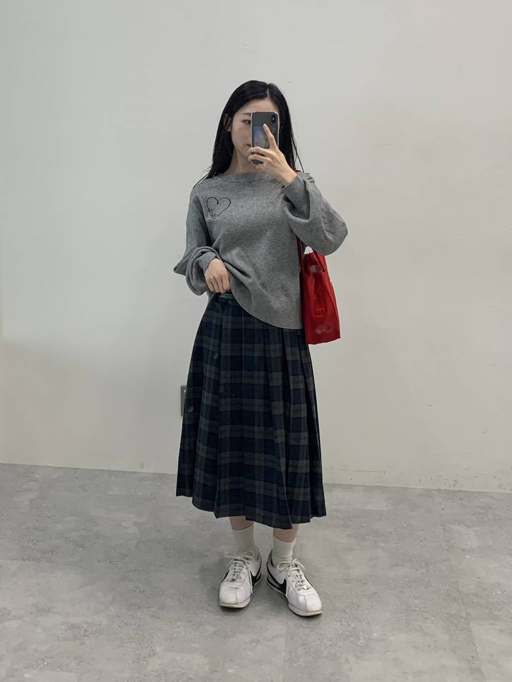 グレー系のニット/セーター、グレー系のスカートを着用したレディースの秋コーディネートの2枚目の写真