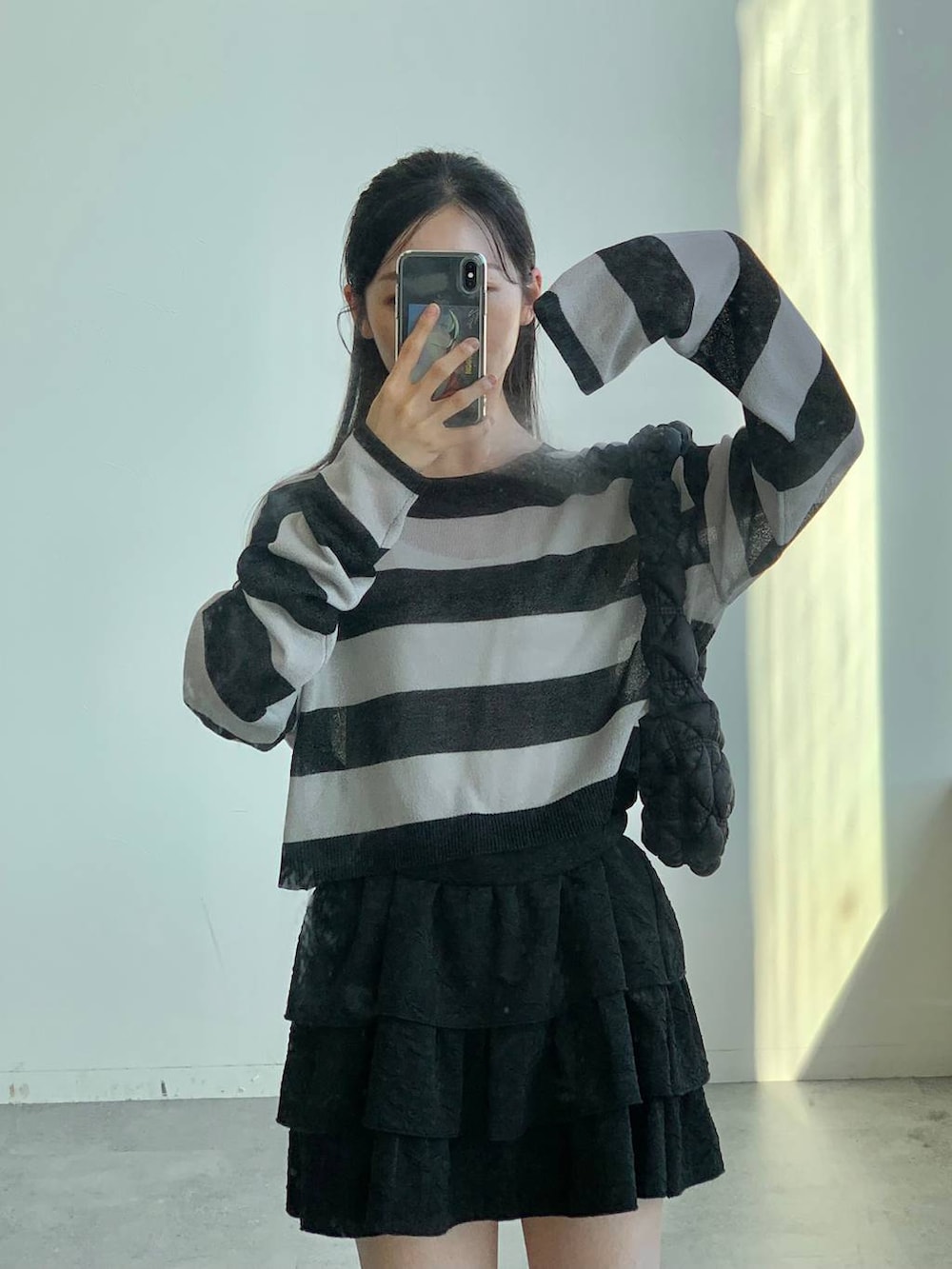 ブラック系のショルダーバッグ、ブラック系のスカート、ブラック系のニット/セーターを着用したレディースの秋コーディネートの10枚目の写真