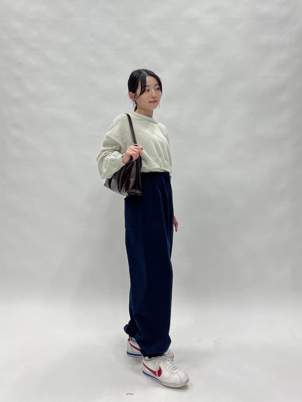 グリーン系のニット/セーターを着用したレディースの春コーディネートの4枚目の写真