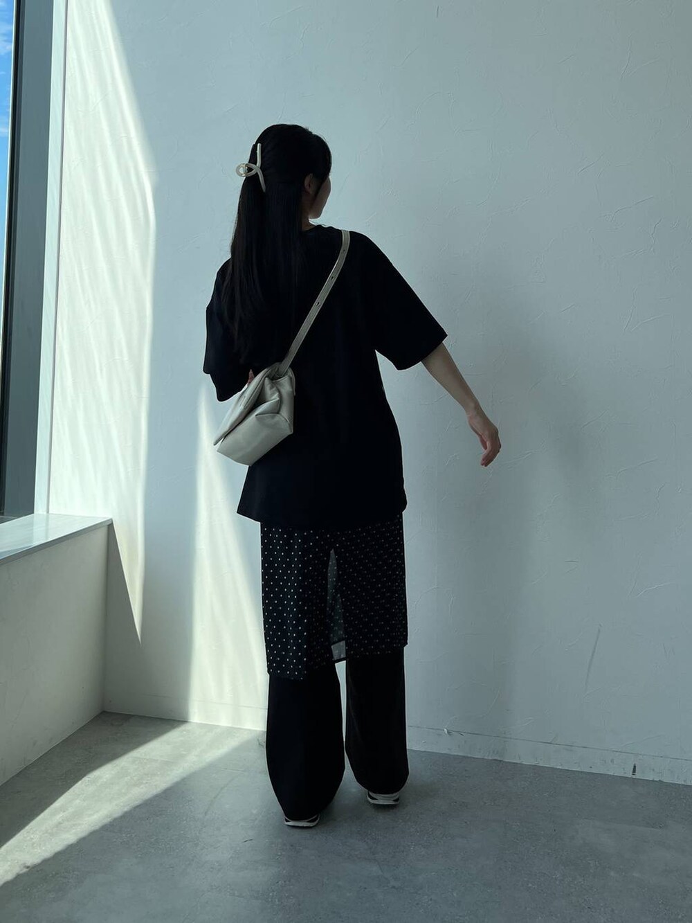 ホワイト系のハンドバッグ、ブラック系のスカートを着用したレディースの夏コーディネートの4枚目の写真