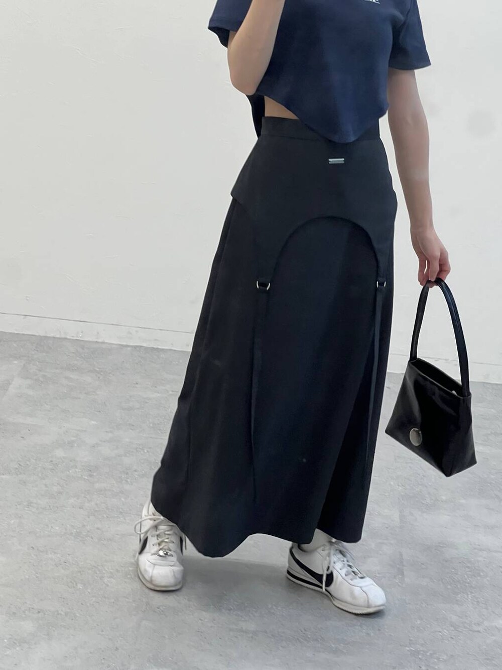 グレー系のスカート、ブラック系のハンドバッグ、ブルー系のTシャツ/カットソーを着用したレディースの夏コーディネートの6枚目の写真