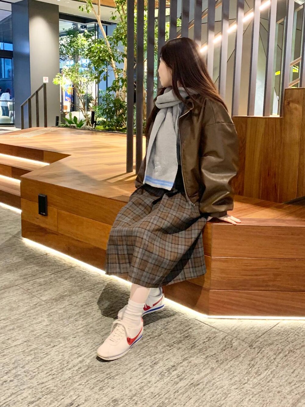 グレー系のカーディガン/ボレロ、ブラウン系のブルゾン、ブラウン系のスカートを着用したレディースの秋コーディネートの5枚目の写真