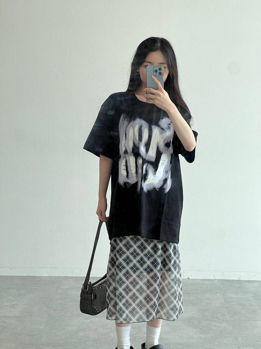 グレー系のスカート、ブラック系のトートバッグ、ブラック系のTシャツ/カットソーを着用したレディースの夏コーディネートの4枚目の写真