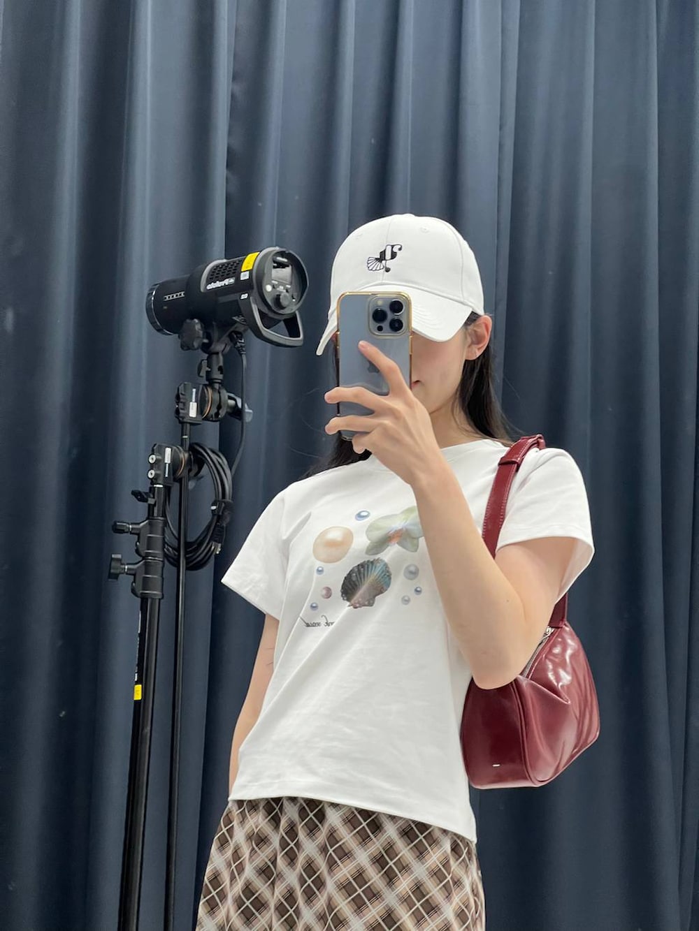 ブラウン系のスカート、ホワイト系のTシャツ/カットソーを着用したレディースの夏コーディネートの2枚目の写真