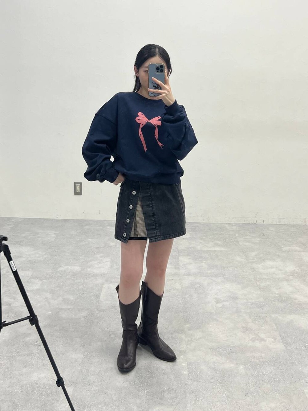 ブラウン系のスカート、ブラック系のデニムパンツを着用したレディースの春コーディネートの3枚目の写真
