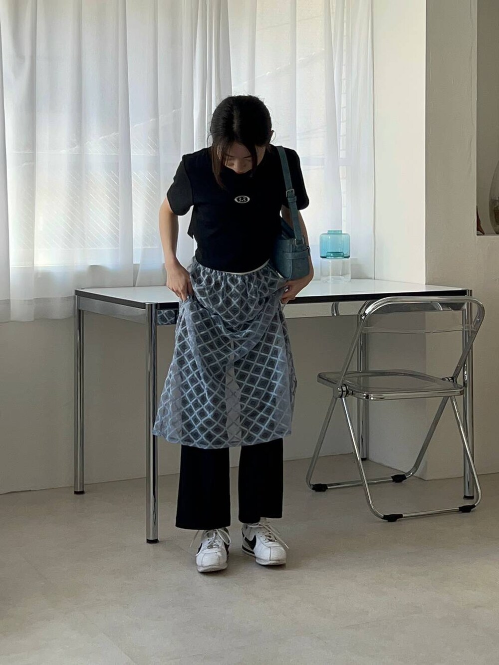 ブルー系のスカート、ブラック系のTシャツ/カットソーを着用したレディースの春コーディネートの4枚目の写真