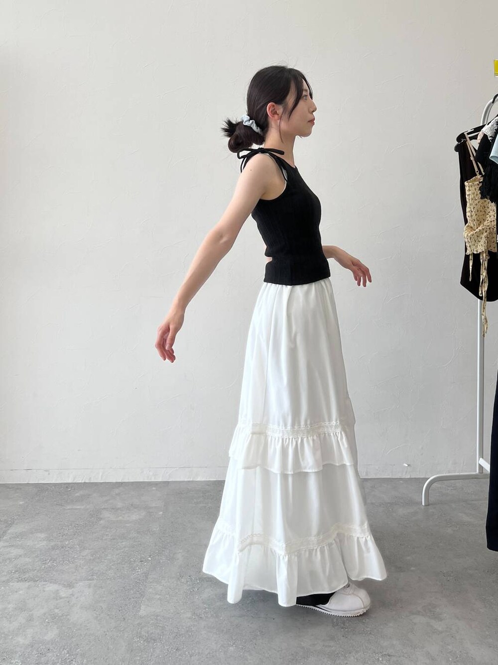 ホワイト系のスカート、ブラック系のキャミソールを着用したレディースの夏コーディネートの2枚目の写真