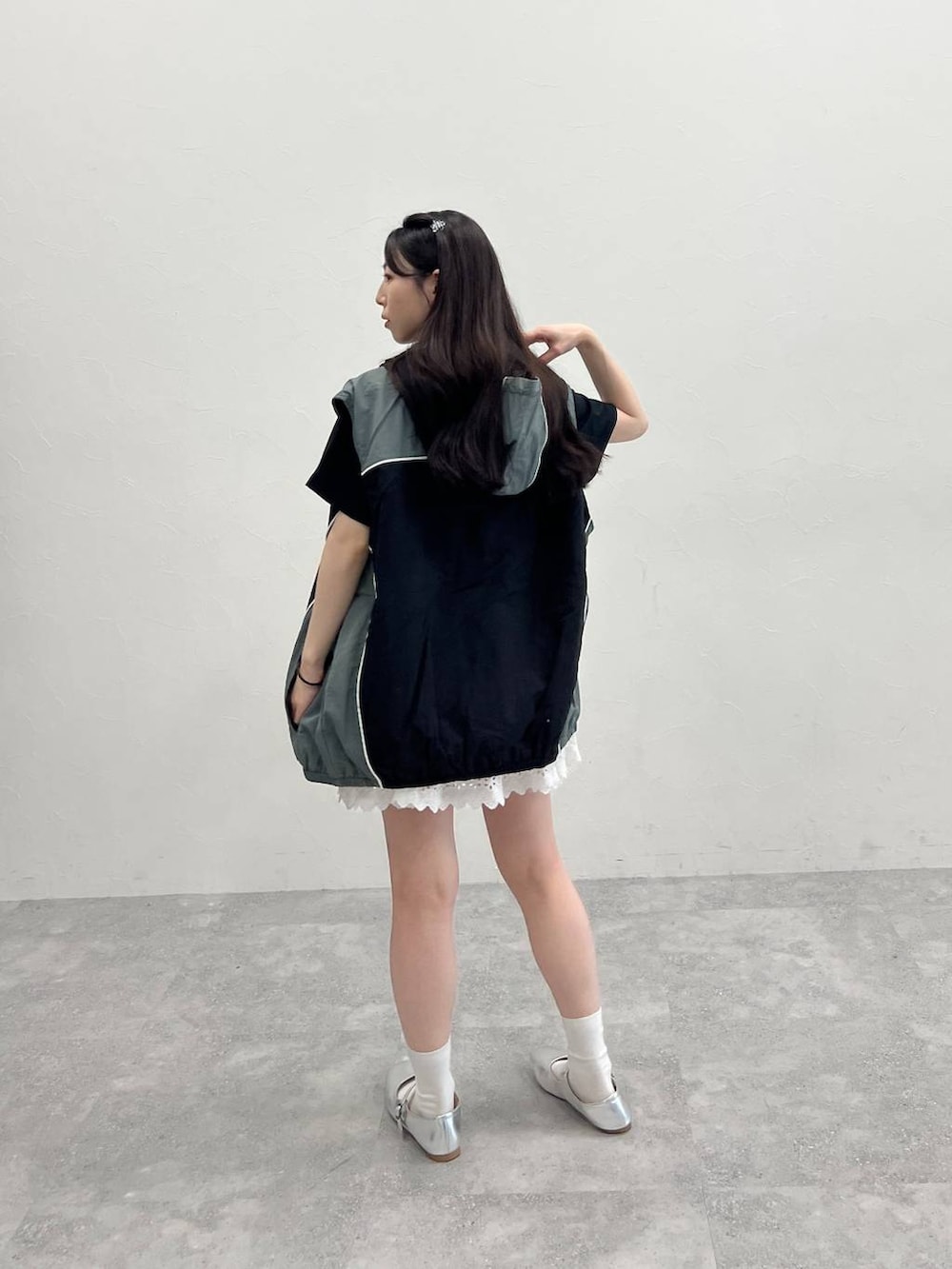 ホワイト系のスカート、ブラック系のナイロンジャケット、ブラック系のTシャツ/カットソーを着用したレディースの春コーディネートの3枚目の写真
