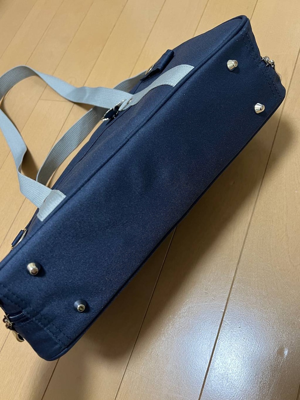 ブルー系のトートバッグ、ブラック系のジャケット/アウター、ホワイト系のTシャツ/カットソーを着用したレディースの冬コーディネートの7枚目の写真